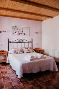 a bedroom with a large bed with white sheets and pink walls at Apartamentos El Callejón in Riópar