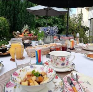 a table with plates of food and a bowl of fruit at La Crevette in Villerville