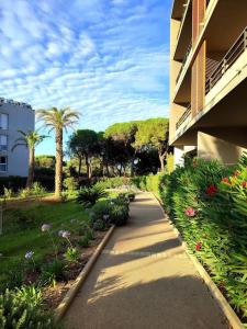een stoep naast een gebouw met bloemen en palmbomen bij Appartement neuf Piscine in Fréjus +16 foto's