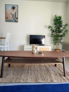 een houten salontafel in een woonkamer met een tv bij Appartement neuf Piscine in Fréjus