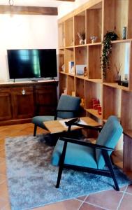 a living room with two chairs and a table and a tv at Il-Veduta: Country-estate in Oroslavje