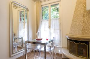 a dining room with a table and chairs and a fireplace at Margutta's Garden in Rome