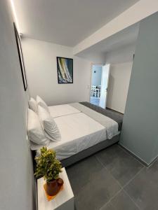 a bedroom with a bed and a plant on a table at Skiathos Holiday Resort in Skiathos +37 photos