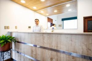 a man standing at a counter in a salon at Sori Apartments in Lima