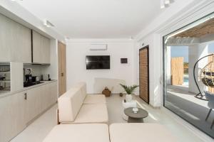 a white living room with a couch and a table at Saint John Halkidiki in Nikiti