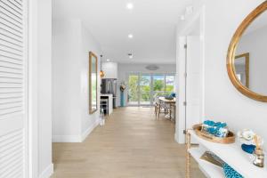 een hal van een huis met witte muren en een spiegel bij Emerald Oasis Deluxe Waterfront Gem, Heated Pool with Dock in Marathon