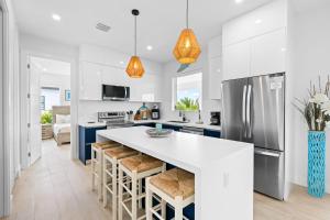 een keuken met witte kasten en een groot eiland met barkrukken bij Emerald Oasis Deluxe Waterfront Gem, Heated Pool with Dock in Marathon