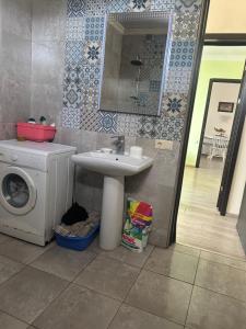 a bathroom with a sink and a washing machine at Kobuleti Family apartment in K'obulet'i +7 photos