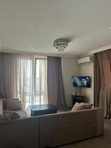 a living room with a couch and a tv at Kobuleti Family apartment in K'obulet'i