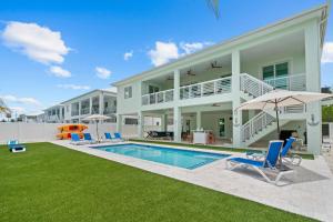 a house with a swimming pool and a yard at Emerald Oasis Deluxe Waterfront Gem, Heated Pool with Dock in Marathon