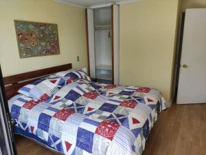 a bedroom with a bed with a quilt on it at Impecable dpto a 2 cuadras de la playa in Viña del Mar