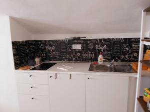 a kitchen with a black wall with writing on it at Domeček in Třeboň