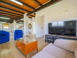 a living room with a large television and blue chairs at Cubo's Villa Di Hermosa View in Villafranco de Guadalhorce