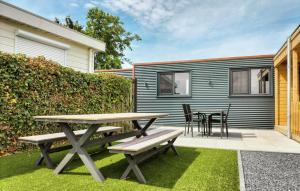 une table de pique-nique et des chaises dans l'arrière-cour d'une petite maison dans l'établissement 2 Bedroom Beautiful Home In Stavenisse, à Stavenisse 17 autres photos