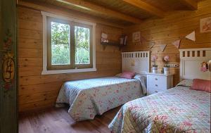 a bedroom with two beds in a log cabin at Casa Pinares de Roche tres dormitorios in Cádiz