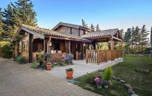 a wooden house with a porch and flowers in front of it at Casa Pinares de Roche tres dormitorios in Cádiz