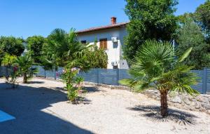 une rangée de palmiers devant une maison dans l'établissement Nice Apartment In Malinska With Wifi, à Malinska 16 autres photos