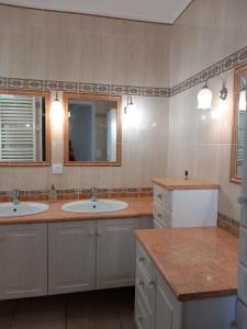 a bathroom with two sinks and a mirror at Douceur Vendéenne in La Roche-sur-Yon