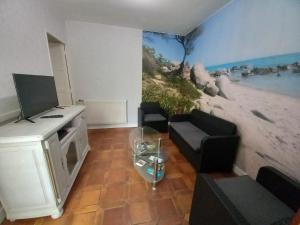 a living room with a beach mural on the wall at Douceur Vendéenne in La Roche-sur-Yon