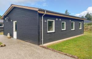 a small black house with at 3 Bedroom Nice Home In Skjern in Skjern +10 photos