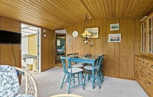 a dining room with a blue table and chairs at 1 Bedroom Gorgeous Home In Aakirkeby in Åkirkeby