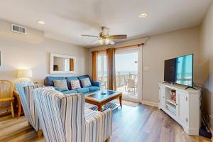 a living room with a blue couch and a tv at The Breeze in Gulf Shores
