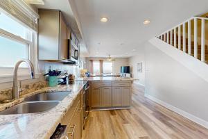 a large kitchen with a sink and a staircase at The Breeze in Gulf Shores