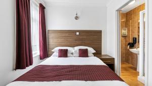 a bedroom with a bed with two red pillows at Sandy Lodge Hotel Newquay in Newquay