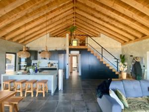 a kitchen and living room with wooden ceilings and a blue couch at Atlantis Pico in Santo Amaro