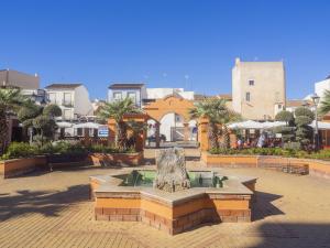 a fountain in the middle of a courtyard with buildings at Cubo's Villa Di Hermosa View in Villafranco de Guadalhorce