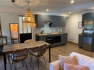 a kitchen and living room with a table and chairs at Les Logis de Candide in La Teste-de-Buch