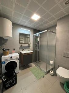 une salle de bains avec douche, toilettes et lavabo dans l'établissement Sky Angel Apartment, à Skopje