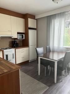 a kitchen with a table and chairs in a kitchen at Apartment Mäyränkatu in Kokkola