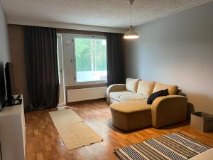 a living room with a couch and a window at Apartment Mäyränkatu in Kokkola