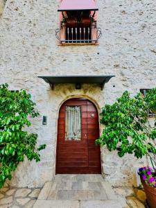 a wooden door on a stone building with a balcony at AL CARDINALE in Fondi