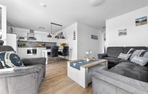a living room with two couches and a kitchen at Am Yachthafen in Olpenitz