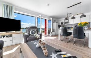 a living room with a large television and a table at Am Yachthafen in Olpenitz