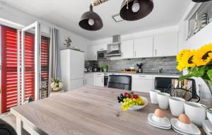a kitchen with a wooden table with a bowl of fruit at Am Yachthafen in Olpenitz +31 photos