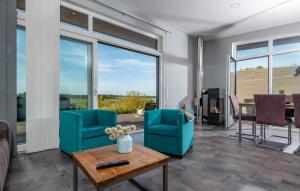 a living room with two blue chairs and a table at Auszeit in Gelting +12 photos