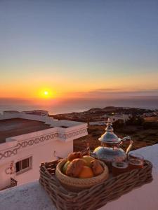 un panier de fruits posé sur un rebord avec le coucher du soleil dans l'établissement Tanger, Vue Mer Panoramique, à Noûnouech 21 autres photos