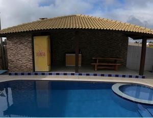ein Haus mit einem Pool vor einem Gebäude in der Unterkunft Casa de praia barra Serinhaém,Carneiros,ilha santo aleixo in Sirinhaém