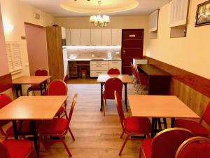 a dining room with wooden tables and red chairs at Pensjonat PANORAMA in Karpacz