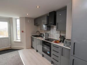 a kitchen with stainless steel appliances and gray cabinets at Apt 1 Hunter's Quay in Bridlington +14 photos