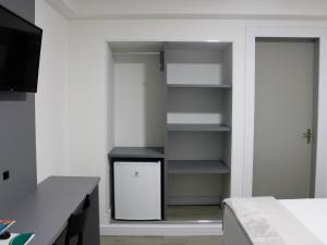 a room with a closet with a refrigerator in it at Hotel Sagres Praia in Balneário Camboriú