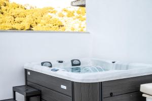 a bath tub in a bathroom with a window at Villa Kamari - Elenes Village in Elénai +50 photos