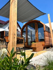 a patio with a black canopy and a bench at Zatoka Marina II in Mechelinki