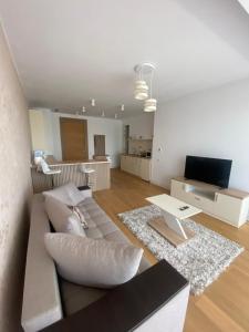 a living room with a couch and a tv at Apartament Naty S 403 Vogh Olimp in Olimp