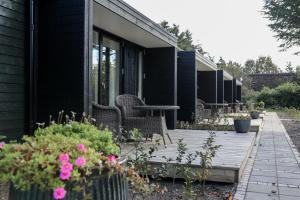 亨讷斯特兰德BLÅBJERGGAARD - Hennebysvej 60的房子上的带椅子和桌子的甲板