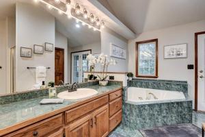 a bathroom with a large tub and a sink and a tub and a tubermott at Rural 6 bedroom cabin - With a Hot Tub! in Exeter +52 photos