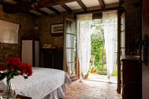 a bedroom with a bed and a large window at La Buca in Castello di Serravalle